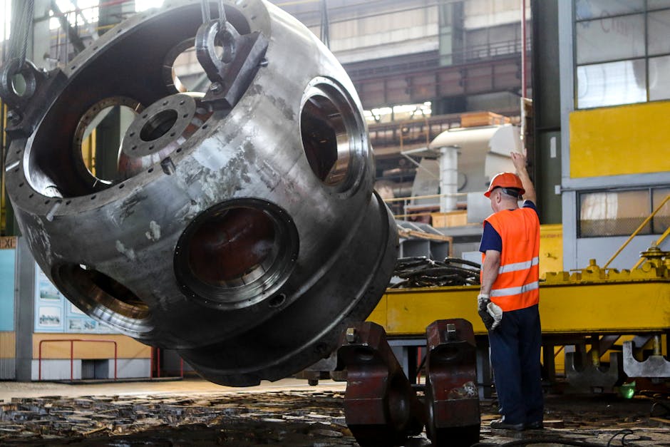 Worker in safety gear operating machinery inside an industrial plant