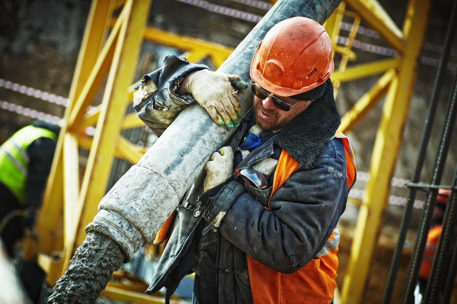 Construction worker in safety gear handling equipment on an active site